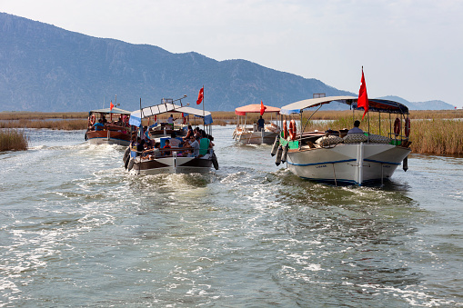 Mugla, Turkey - August 18, 2011: Tourists enjoying the boat taxi journey on the Dalyan channel that will take them to Iztuzu Beach. Iztuzu Beach is a 4.5 km long beach near Dalyan and one of the prime nesting habitats of the loggerhead turtle in the Mediterranean