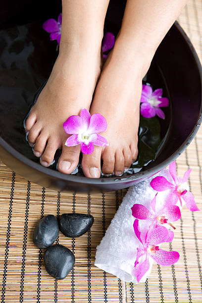 istock feet in foot spa bowl with orchids 146800336