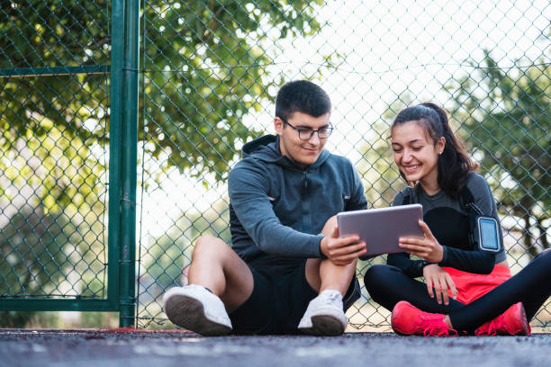 Girl an her coach monitoring her progress on digital tablet. stock photo