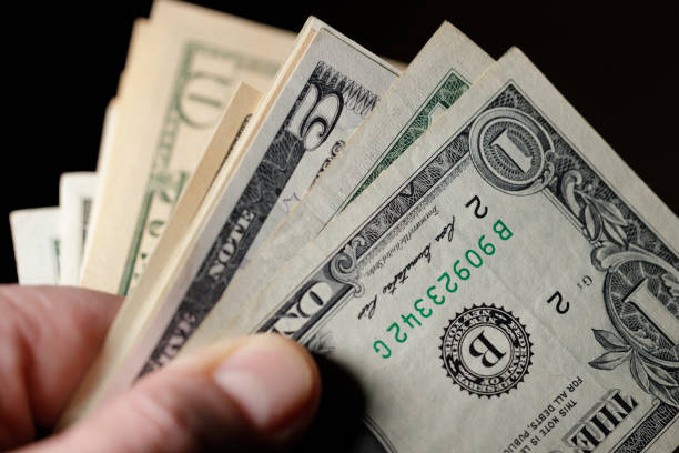 istock mature man holding US Dollar bills 1468014115