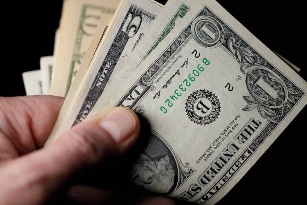 istock mature man holding US Dollar bills 1468014123