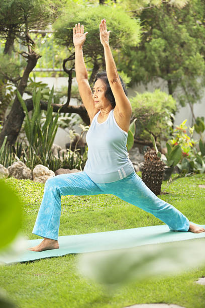 istock Senior woman doing yoga at park 146801491