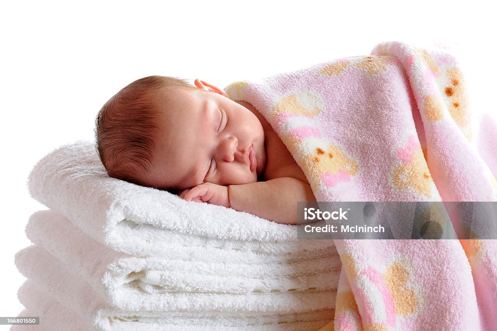 Sleeping Newborn A beautiful newborn sleeping on a stack of white towels and covered with a soft pink blanket.  Isolated on white. Baby - Human Age Stock Photo