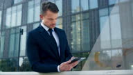 istock DS Young business man standing outside the modern business building using home control app on his tablet 1468020928
