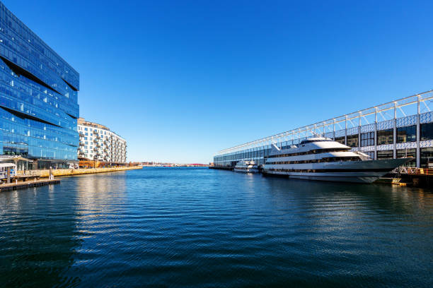 Boston, Massachusetts, USA - February 18, 2023: View between the Commonwealth Pier on the right and the Pier 4 area in the Seaport District. The water leads to the Boston Main Channel of the Boston Harbor. Local Boston cruise ships are docked at Commonweath pier. The Seaport District is a neighborhood in Boston.