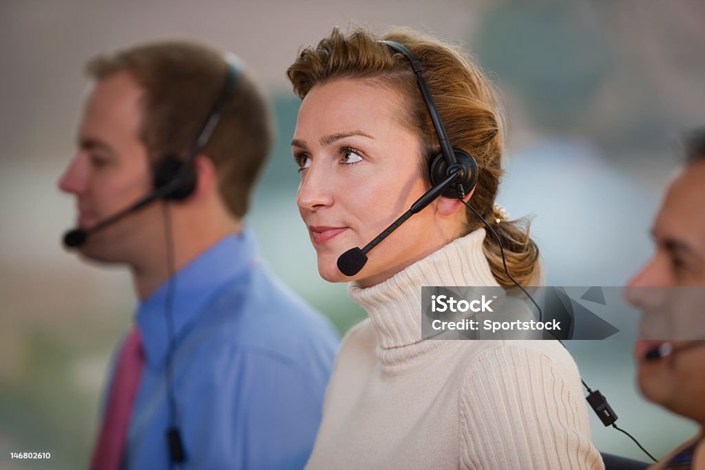 Mujer de negocios usando auriculares - Foto de stock de Agente de servicio al cliente libre de derechos