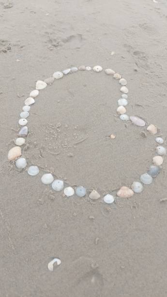istock Heart Made of Shells on The Beach Sand 1468028422