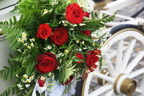 Flowerful wedding carriage with huge bouquet on side. The wedding day is one of the most special days in life. Focus on flowers, wheel defocussed