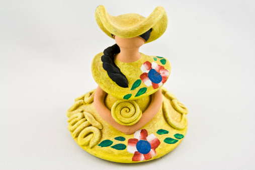 Souvenir doll from the Dominican Republic.  Yellow coloured dress, hand-painted on white background.