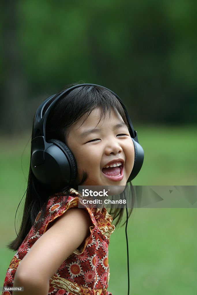 Dziewczynka Słuchanie muzyki i śpiewu na park - Zbiór zdjęć royalty-free (Adolescencja)