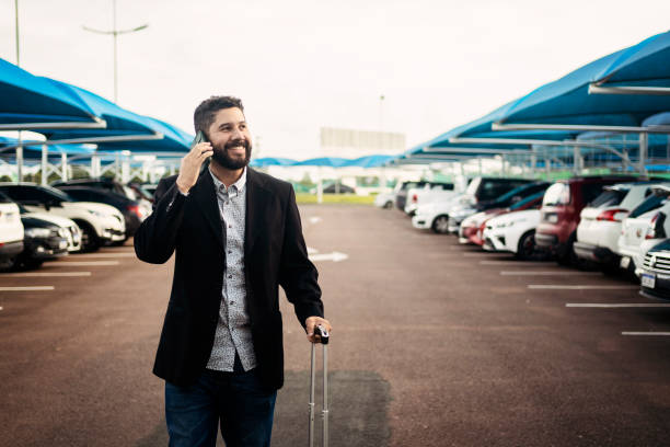 Man walking in airport parking lot stock photo