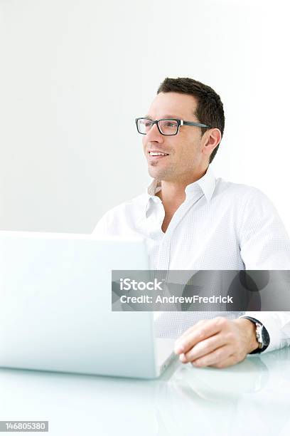 Człowiek Na Laptopie Uśmiecha Się - zdjęcia stockowe i więcej obrazów Biały - Biały, Biurko, Biznes