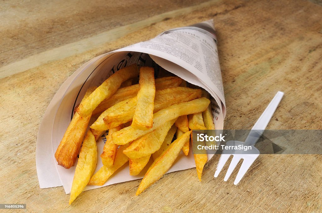 Apples Fries in a newspaper on a table. Fastfood Deep Fried Stock Photo