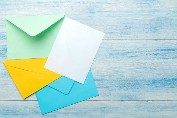 istock Multicolored envelopes with a blank for the text on a blue wooden table. top view 1468061549
