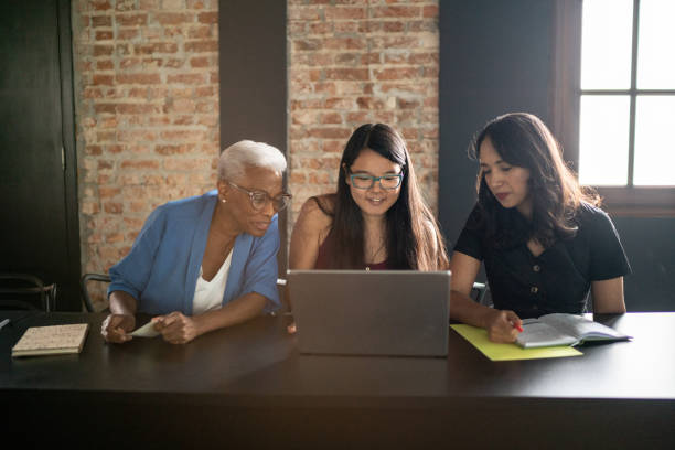 istock Happy colleagues talking and using laptop in the classroom 1468064613