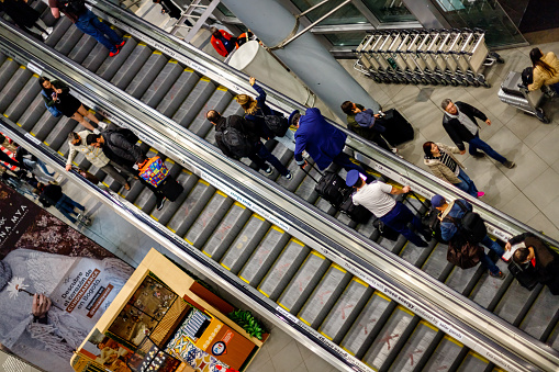 Bogota, Colombia - January 8, 2023: Passengers and crew members go up an escalator at El Dorado airport