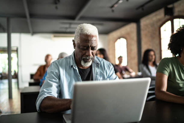 Senior man using laptop in the a seminar