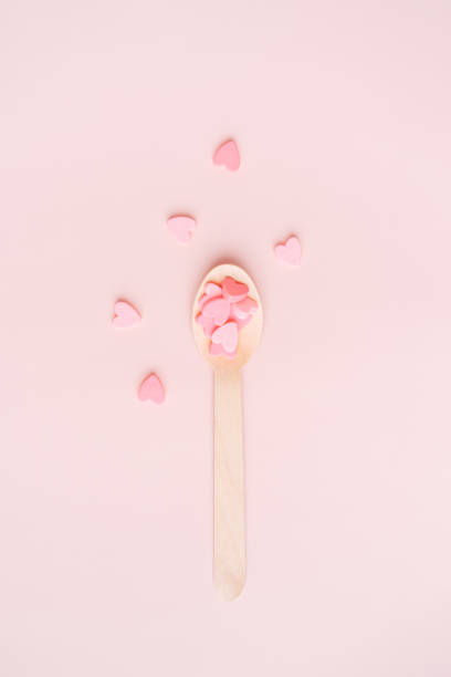 istock Wooden spoon with pink hearts on a pink background 1468069230