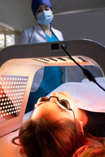 istock Patient exposing her face to red light for blemish reduction. 1468072995