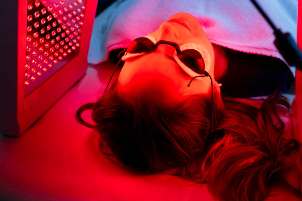 istock Patient exposing her face to red light for blemish reduction. 1468073551