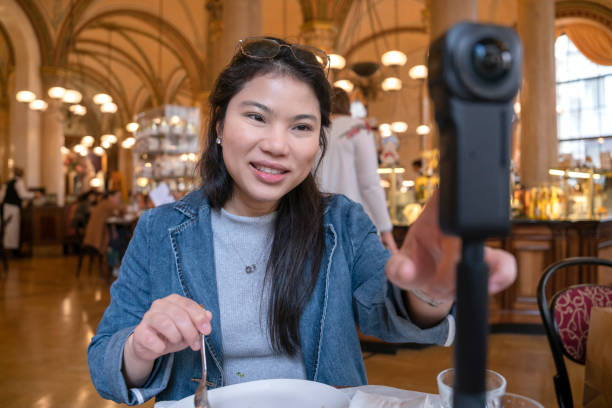 istock Asia travel vlogger introduce great menu famous restaurant while lives streaming for social reel video social media platform,Social media influencer online video of food at cafe, smartphone 1468075329