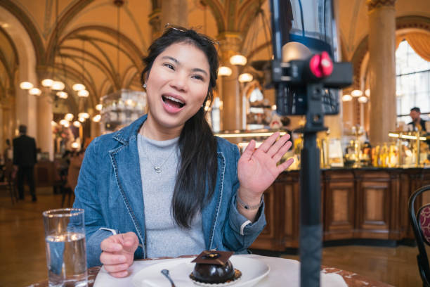 Asia travel vlogger introduce great menu famous restaurant while lives streaming for social reel video social media platform,Social media influencer online video of food at cafe, smartphone