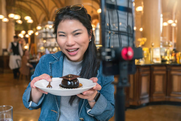 istock Asia travel vlogger introduce great menu famous restaurant while lives streaming for social reel video social media platform,Social media influencer online video of food at cafe, smartphone 1468075346