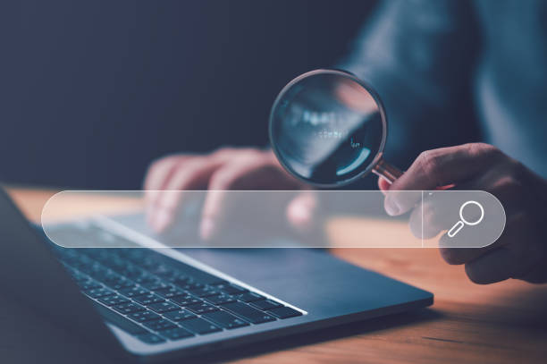 istock Businessman use magnifying glass Search On Virtual Screen Data Search Technology Search Engine Optimization. Man use computer to Searching for information. Using Search Console for data, info. 1468080317