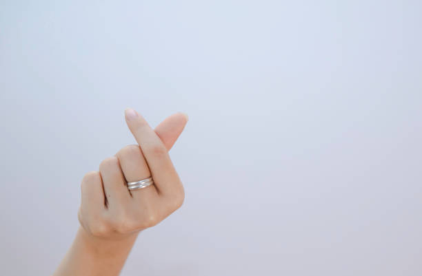 白い背景に小さな心を示す女性の手、女性の手による接写ミニハートサイン - solated on white ストックフォトと画像
