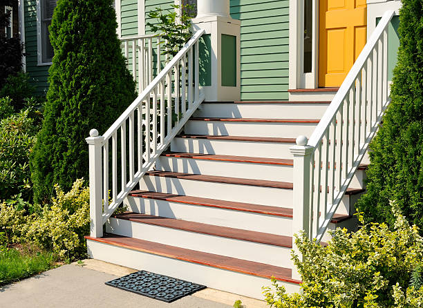 Front Stoop Doorstep and front stoop close-up. House entrance framed by landscaped garden matching green and yellow colors of front door and walls. railings stock pictures, royalty-free photos & images