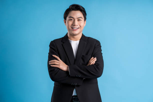 istock Young business man wearing a vest posing on a blue background 1468082934