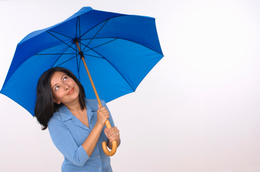 Hispanic woman with a blue umbrella looking up preparing for a rainy day