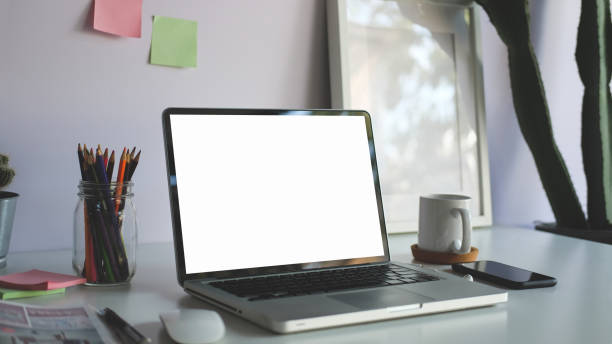 istock Laptop computer with blank display, photo frame, coffee cup and stationery on white table. 1468089161