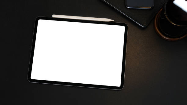 istock Digital tablet , stylus pen, notebook and cup of coffee on black leather table. 1468089370