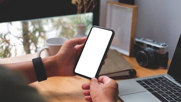 istock View over shoulder of man hands holding smart phone. Empty screen for your advertise text. 1468089648