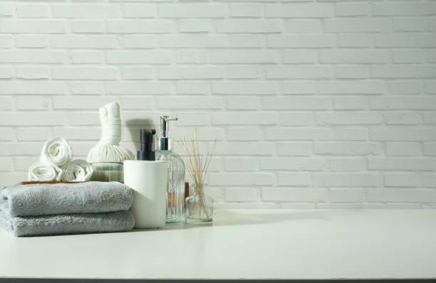 istock Beauty treatment items for spa  on white table with towels, essential oils and herbal compress balls. 1468090445