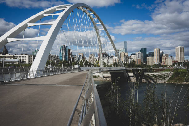 View of the Walterdale suspension bridge and Saskatchewan river in Edmonton Alberta Canada during the day with view of Edmonton skyline