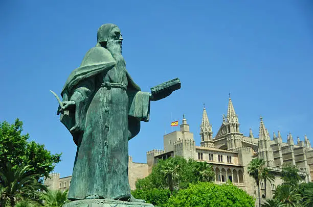 The old statue of Ramon Llull and the cathedral in Palma de Mallorca.