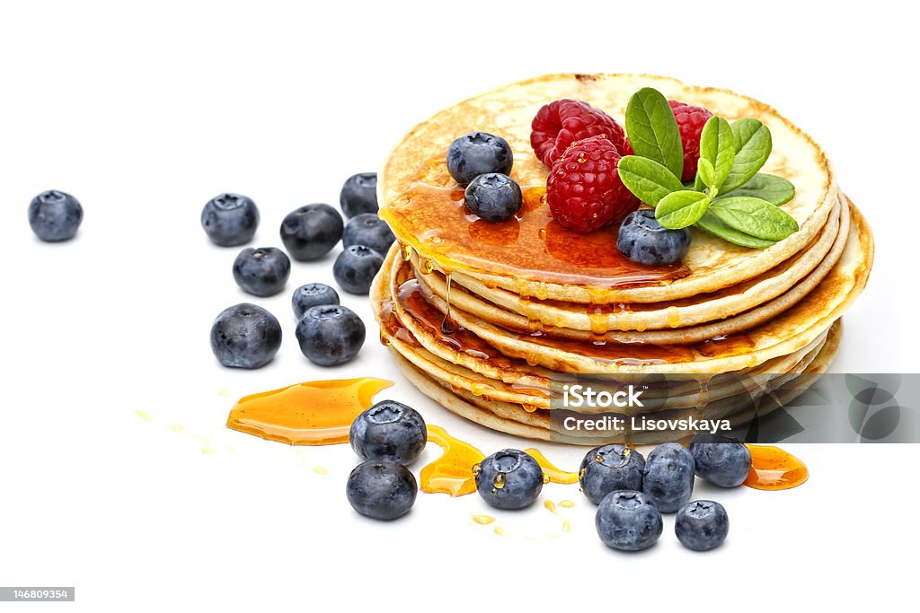 pancakes with honey, raspberries and bilberries small pancakes topped with honey, raspberries and bilberries Berry Fruit Stock Photo