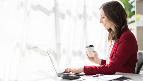 istock American businesswoman smiling confidently using laptop computer working on financial statistics presentation with graph document Female accountant analyzing data in office looking at camera 1468094522