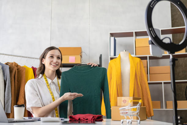 istock A beautiful blogger shows off her clothes in front of a smartphone camera while recording videos, vlogs and live streams at her store, online clothing sales concept on social media. 1468094582