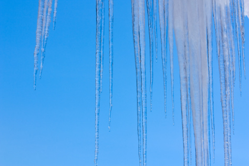 Icicles in winter with a blue sky.