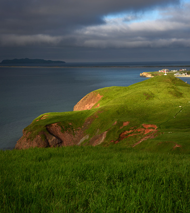 Grassy hill of Magdalen Islands with sunbeam, Les Demoiselles, Québec