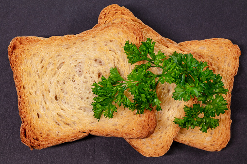 Three Biscotti Crackers  and Curly Parsley on Black Background