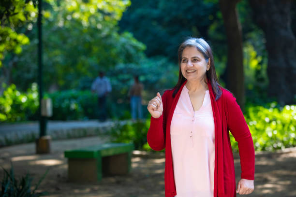 Indian senior woman doing exercise or jogging at park.