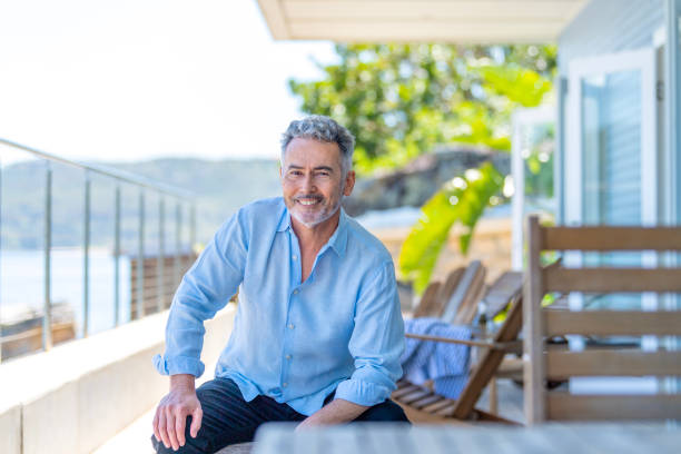 istock Mature man sitting on the balcony looking at the camera. 1468106554
