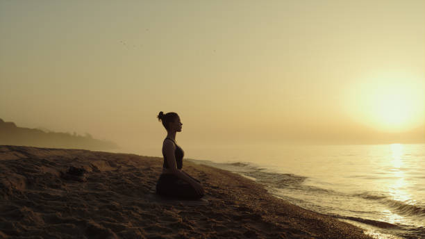 istock Yoga woman practicing meditation on sandy beach.Lady relaxing on nature. 1468109190