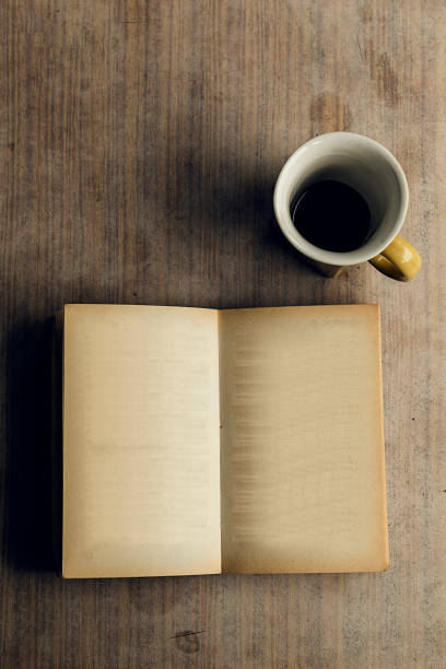 istock An open book with blank pages and a cup of coffee. Melancholy 1468110983