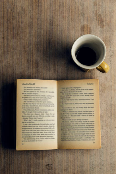 istock An open book with blurred pages and a cup of coffee. Melancholy 1468110992