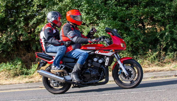 Potterspury,Northants, UK - August 14th 2022. Man riding 2002 600cc Yamaha Fazer with pillion passenger on an English country road